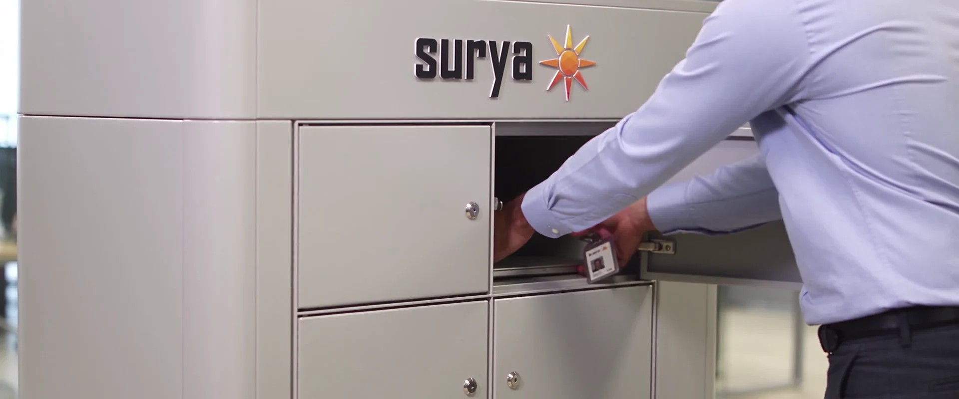 A worker collecting a replacement laptop from a Surya Smart Locker.